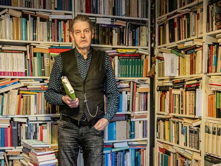 Josef Oberhollenzer, inmitten der Bücher, die sein Schreiben stützen:
„Läuft die Literatur der Wirklichkeit hinterher oder die Wirklichkeit der Literatur?“