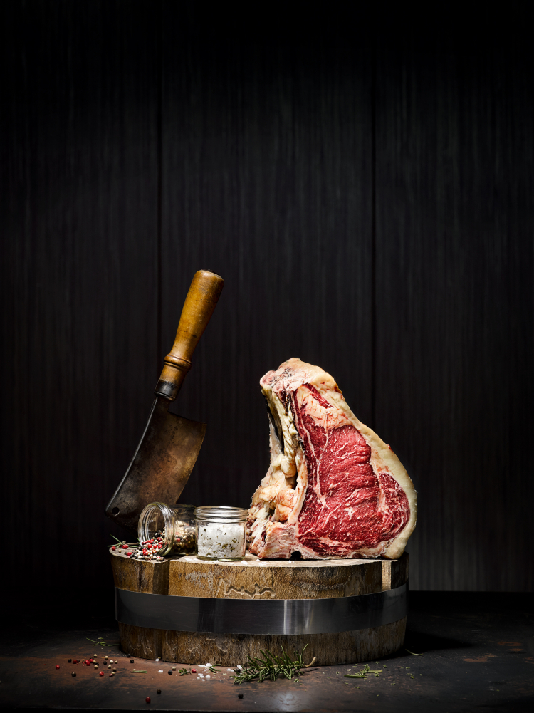 Beim Dry Aging wird das Fleisch am Knochen über einen längeren Zeitraum und bei kontrollierter Temperatur und Luftfeuchtigkeit abgehängt: Das Fleisch wird dadurch sehr zart – und es entwickelt sich eine einzigartige Fettmarmorierung. Dry Aged Beef