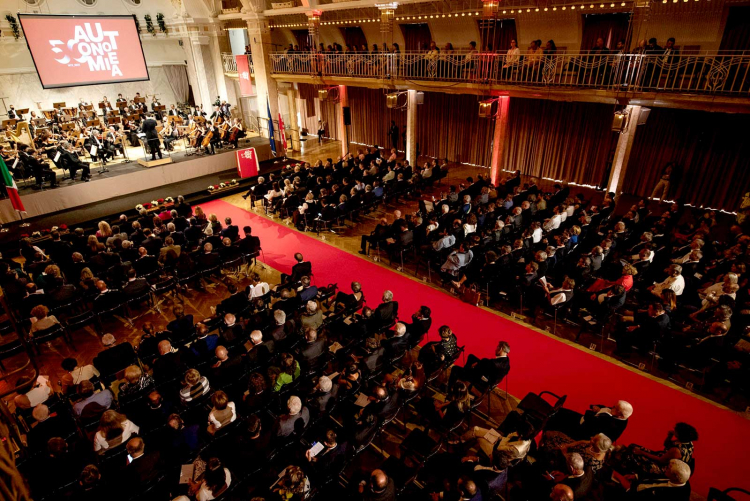 Im Kurhaus in Meran drängen sich die Ehrengäste zur Feier des 50. Jahrestages des Autonomiestatuts: Man ist sich einig, das Statut ist ein Modell. Kurhaus in Meran