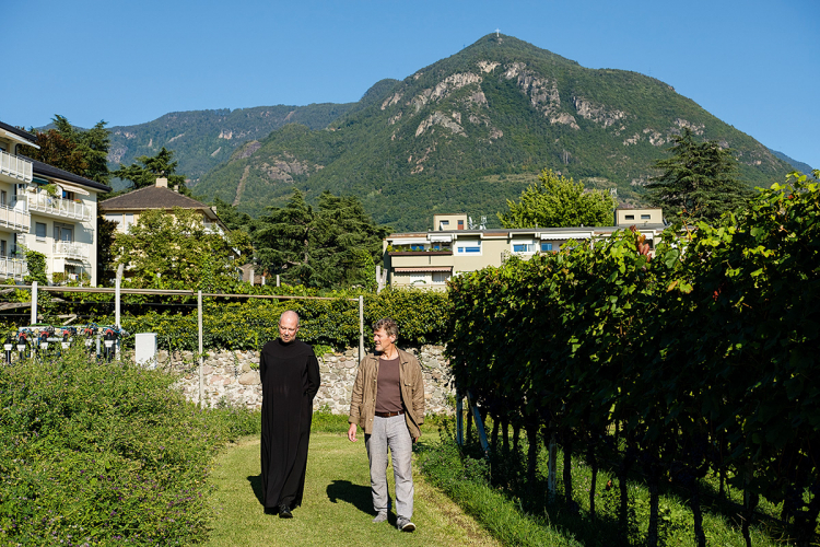 Spaziergang im Klostergarten der Abtei, dort wo der berühmte Lagrein Riserva Muri Gries herkommt: Markus Larcher porträtiert für diese ff Ulrich Kössler, Pfarrer von Gries. Beim Treffen kamen die beiden drauf, dass sie sich schon mal begegnet waren. Kössler hat vor 20 Jahren in einem Theaterstück mitgespielt, bei dem Larcher Regie führte. „Damals“, so Larcher, „hatte Kössler lange Haare und war für liebenswerten Unfug bei den Proben immer zu haben.“
Markus Larcher porträtiert für diese ff Ulrich Kössler, Pfarrer von Gries